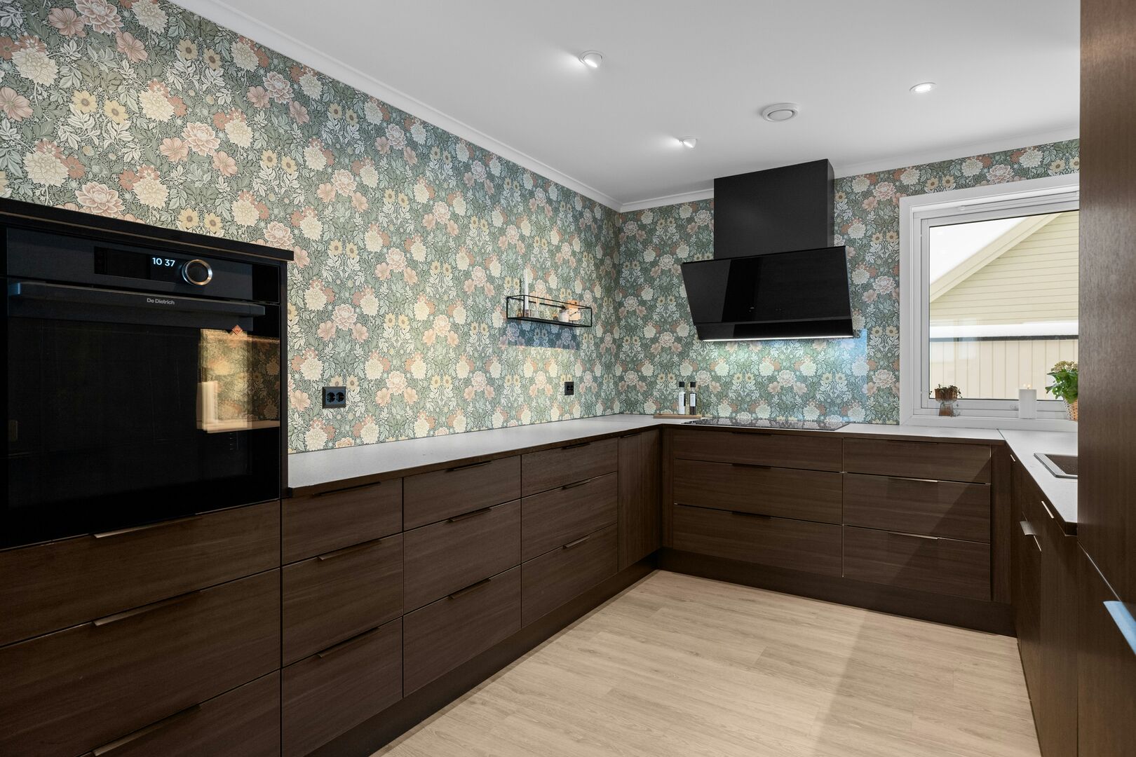 A modern, custom kitchen remodel with dark cabinets and a large island.